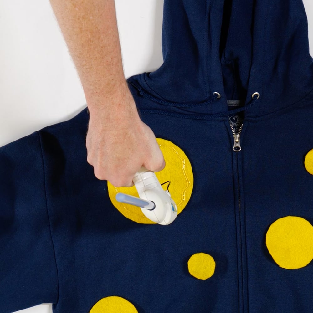 gluing felt circles onto hoodie with glue gun